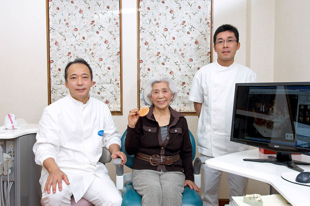 インプラント治療を終えた患者さんとともに　小池院長　患者さん　江口副院長の画像